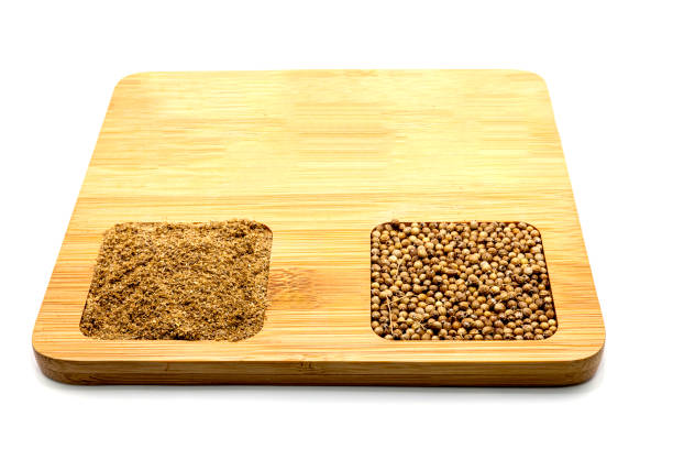 Coriander seeds and ground coriander on a wooden board. isolated on white background. Space available.