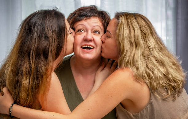 istock Adult daughters kiss their mother from different sides 2157635140