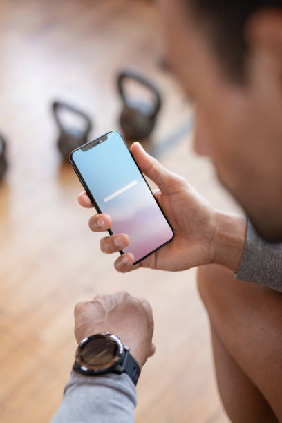 istock Coach using a mobile phone and a watch to check his pulse 2157637306