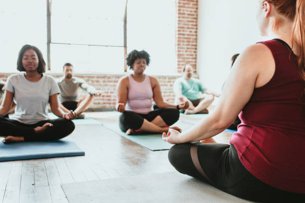 istock People meditating in a yoga class 2157637328