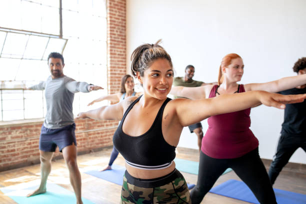 istock Diverse people practicing a Virabhadrasana yoga pose 2157637392