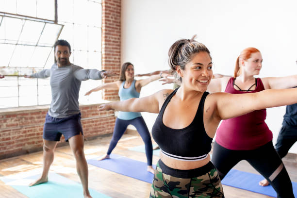 istock Diverse people practicing a Virabhadrasana yoga pose 2157637393
