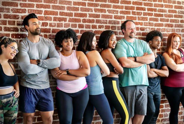 istock Group of sportive people standing by a brick wall 2157637688