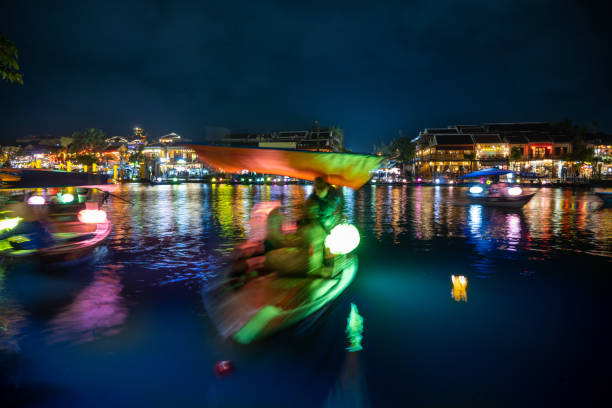 Experience the enchanting beauty of Hoi An, Vietnam, with boats and lanterns illuminating the ancient town. This picturesque scene captures the timeless charm and vibrant culture of this historic destination. Seen at night.
