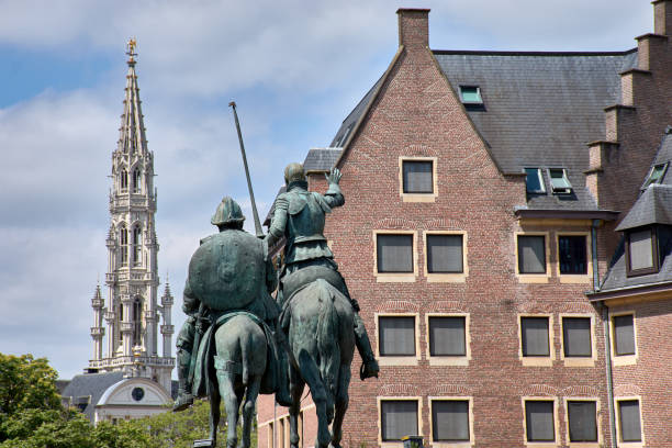 Brussels, Belgium; June, 08,2024; Statue of Don Quixote looking towards the gothic bell tower of the town hall in Brussels