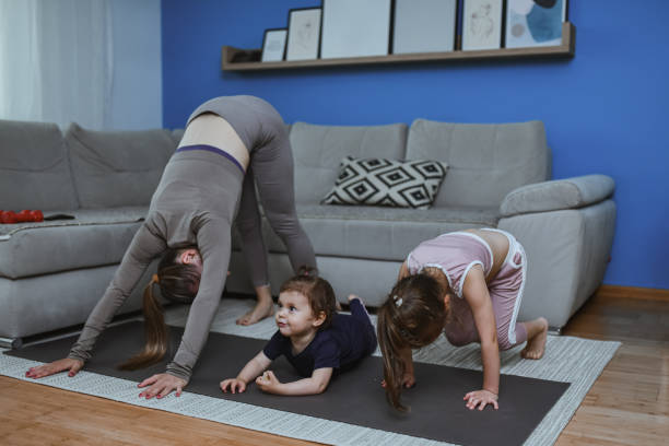 istock Downward Dog For Flexibility Practiced At Home By Mother And Daughters During Yoga Routine 2157648498