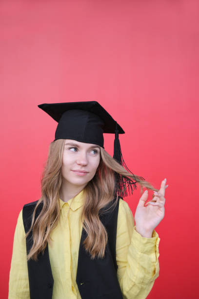 istock Young beautiful blond female in graduation cap with emotional expression 2157650392