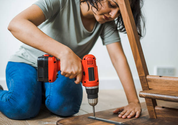 istock Woman using hand drill to assemble a wooden table 2157651292