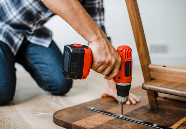 man using hand drill to assemble a wooden table - bricolage imagens e fotografias de stock
