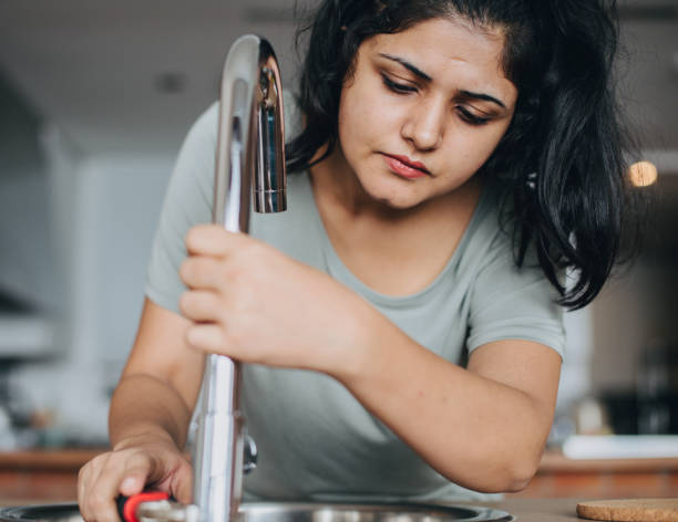 istock Woman fixing the kitchen sink 2157651526