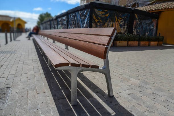 istock Wooden bench with a blurry woman at the end 2157653419
