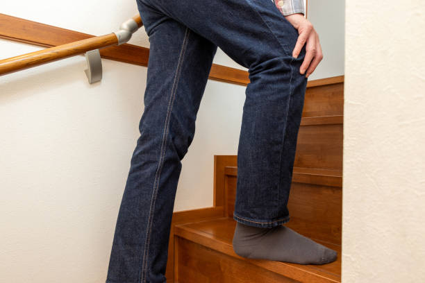 istock A man climbs the stairs with his hand on his knee 2157655891
