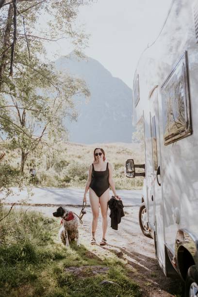 istock Woman in bathing suit with dog by her campervan 2157657042