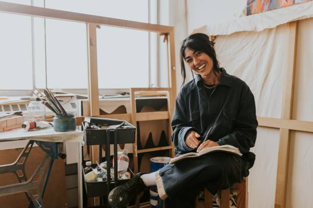 Woman artist reading and studying in her studio