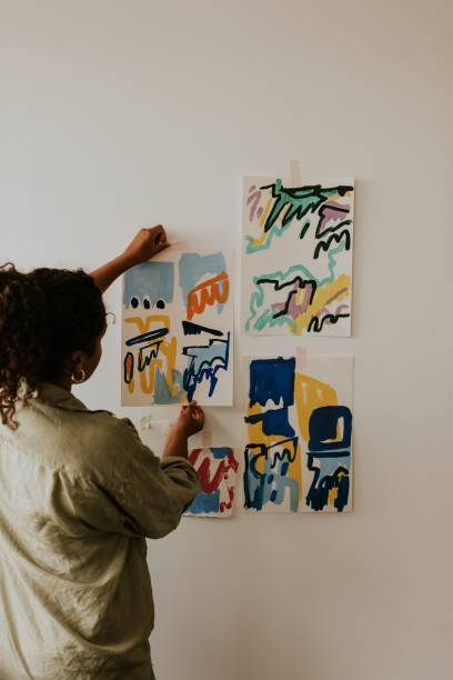 istock Woman artist putting her abstract artwork on the mood board wall 2157657603