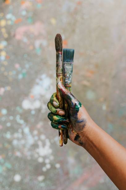 istock Hands holding paint brush, covered in paint 2157657670