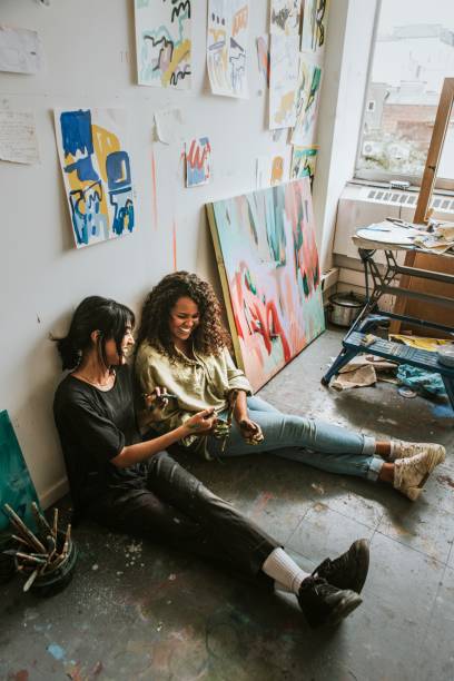 istock Artist friends sitting on the floor in an art studio 2157657675