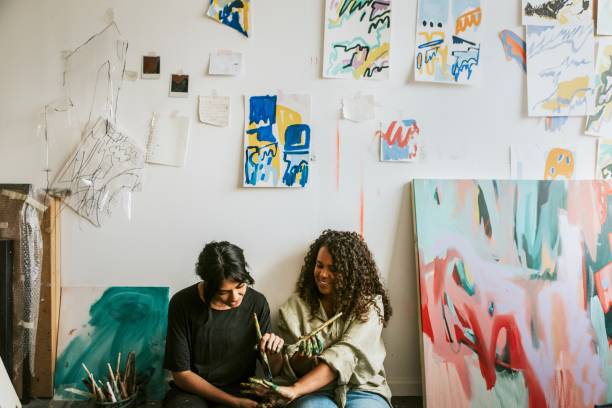 Woman artist friends exchanging ideas in their studio