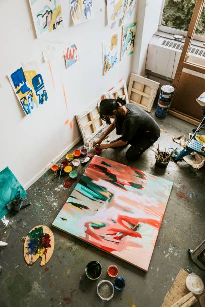 istock Woman artist working on her paint canvas in her studio 2157657692