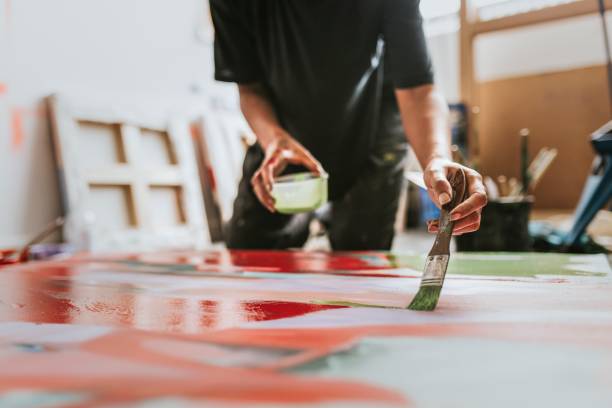 istock Woman artist working on her paint canvas in her studio 2157657700