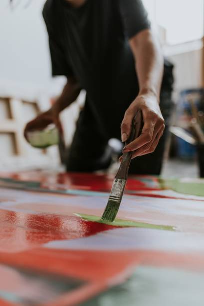 Woman artist working on her paint canvas in her studio