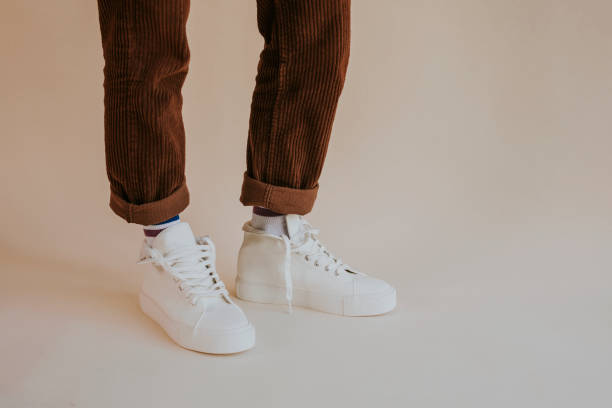 istock White canvas sneakers with untied laces on model 2157659326