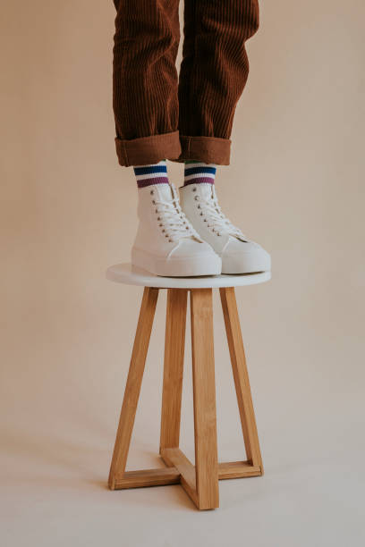istock Model in white high top sneakers standing on chair 2157659332