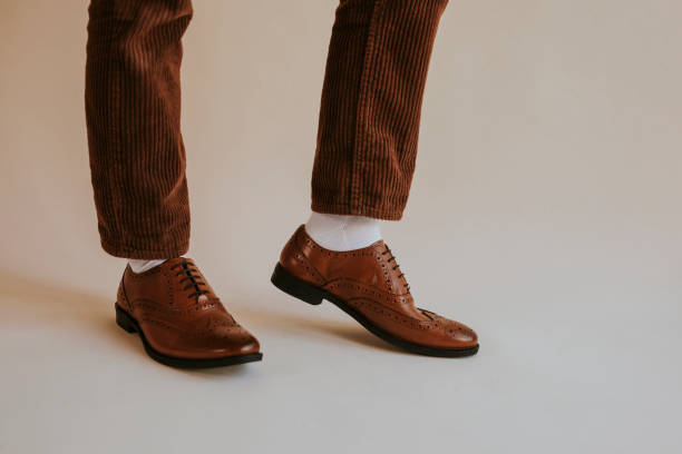 istock Men's leg in brown leather shoes 2157659334