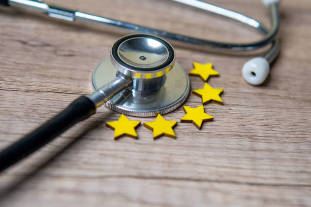 istock Closeup image of stethoscope and five stars on wooden table with copy space. 2157660016