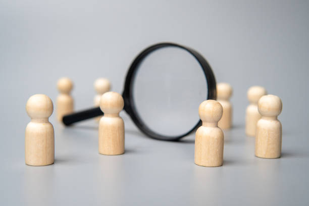 istock Wooden dolls and magnifying glass. 2157660122
