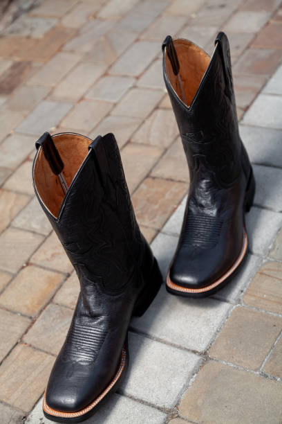 istock Cowboy boots stand on paving slabs 2157660616