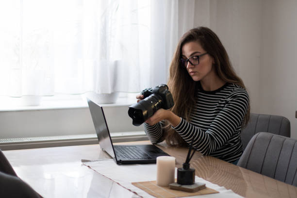 istock Female photographer checking her images on her camera, preparing for edit. 2157661131