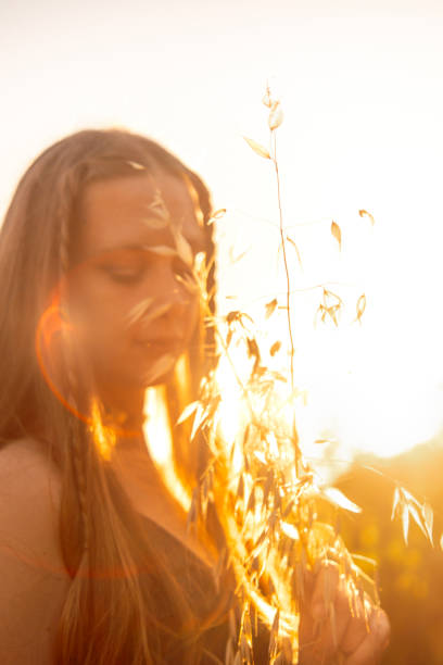 Portrait of a woman with long blonde hair with sun setting in the background