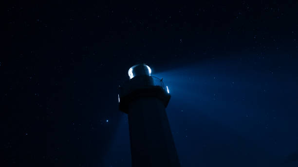 istock Lighthouse shines its light under the starry sky 2157662752