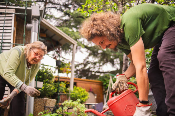 istock Young man with a green thumb assisting a senior lady 2157664375