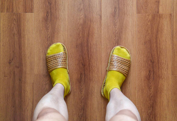 Leather sandals stand on a wooden floor.