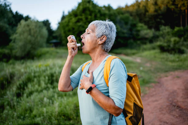 istock Senior woman using an asthma inhaler in nature 2157668370