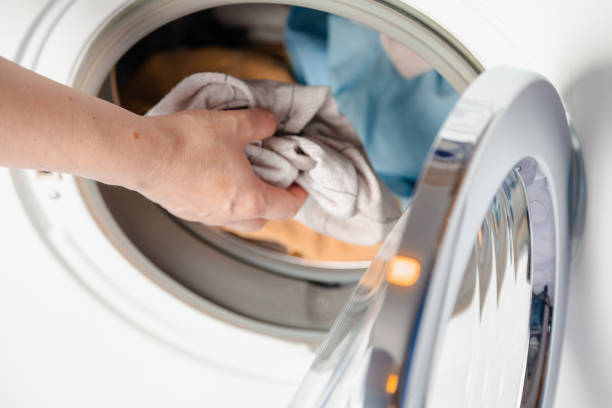 istock Hands putting laundry in the washing machine 2157671961