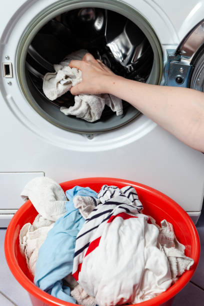 istock Hands take out the washed clothes from the washing machine 2157672029
