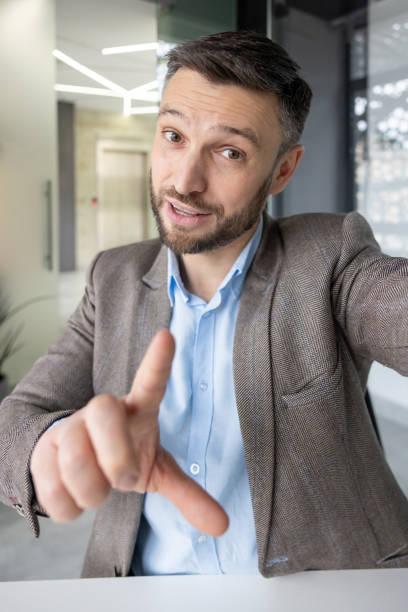 istock Businessman waving during a video call in modern office 2157673286