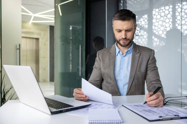 istock Professional man reviewing documents at modern office desk 2157675926