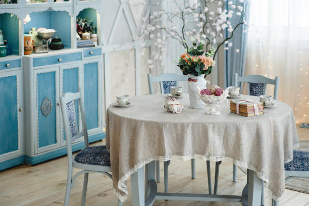 istock Charming interior with pastel blue furniture, elegant table setting, and floral decor. Lace tablecloth and antique teacups add a touch of sophistication and vintage charm 2157680676