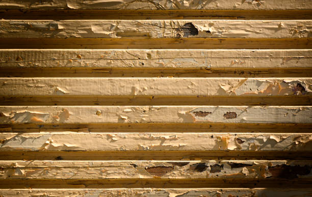 Texture of antique wooden boards with cracked paint in yellow