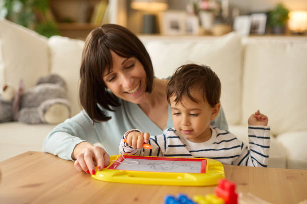 istock Mom teaching cute boy drawing on board together at home 2157689797