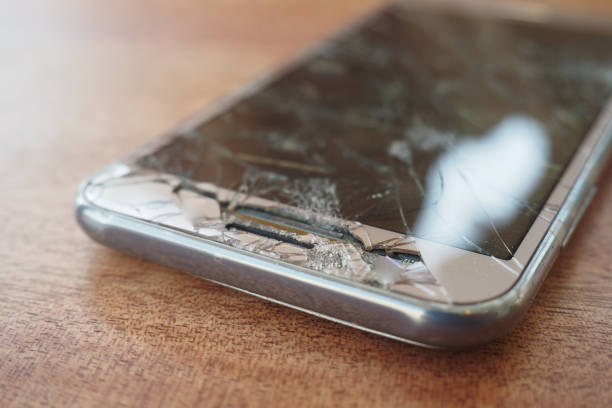 Top view of broken smart phone on color background.