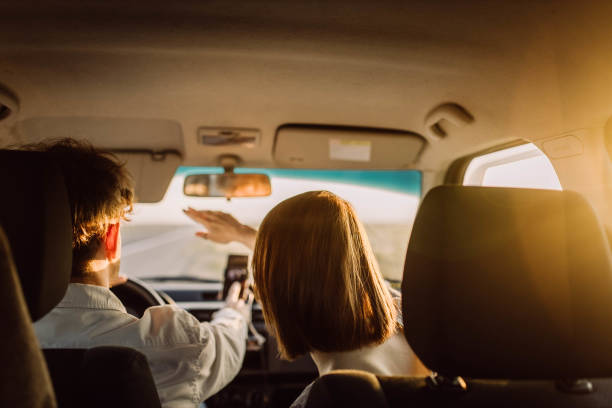 young couple in a car on a summer trip