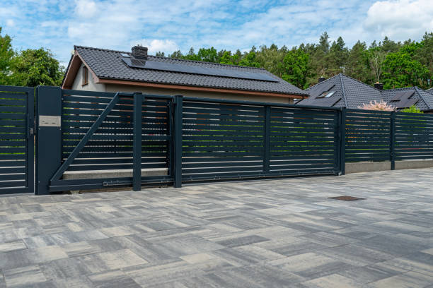 istock A modern panel fence in anthracite color, visible sliding gate to the garage and a slab driveway. 2157696844