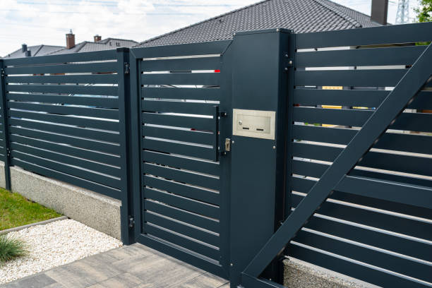 istock A modern panel fence in anthracite color, a visible sliding gate to the garage and a wicket with a letterbox. 2157696849
