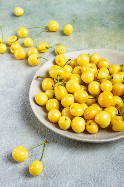 istock yellow cherry, cherry berry, scattered on a plate, top view, no people, 2157699856