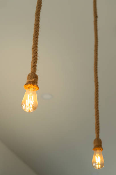 istock Rope ceiling lighting bulb, glowing in warmlight shade. 2157700218